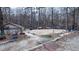 Community sand volleyball court with lighting and bleachers surrounded by a forest at 6317 Lakeland Dr, Raleigh, NC 27612