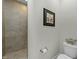 Neutral tiled walk-in shower and a toilet at 65 Balsam Ln, Clayton, NC 27527