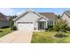 Charming one-story home with a manicured lawn, attached garage, and welcoming front porch at 65 Balsam Ln, Clayton, NC 27527