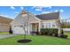 Attractive one-story home with green lawn, attached garage, and meticulously trimmed bushes at 65 Balsam Ln, Clayton, NC 27527