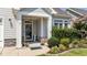 Charming front entrance with decorative door, stone accents, and inviting landscaping with flowering plants at 65 Balsam Ln, Clayton, NC 27527