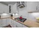 Kitchen featuring white cabinets, stone countertops, stainless hood vent, and gas range at 65 Balsam Ln, Clayton, NC 27527