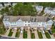 Aerial view of townhomes showcases the community's layout with individual driveways, green spaces, and mature trees at 707 Sutter Gate Ln, Morrisville, NC 27560