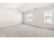Spacious bedroom with carpet, vaulted ceiling, ceiling fan, and bright natural light from two large windows at 707 Sutter Gate Ln, Morrisville, NC 27560