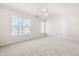 Large carpeted bedroom with vaulted ceiling, ceiling fan, bright windows, and two doors at 707 Sutter Gate Ln, Morrisville, NC 27560