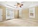 Bedroom featuring a door to an outdoor patio, windows and a ceiling fan at 7373 Newport Ave, Raleigh, NC 27613