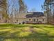 View of the backyard of a yellow home with a grill, a patio, and a deck with wood railings at 77 Double Oak Dr, Pittsboro, NC 27312