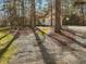 A driveway leads through a stand of tall trees to a yellow house at 77 Double Oak Dr, Pittsboro, NC 27312