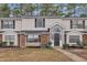 Charming exterior view of a two-story townhome with a brick facade and manicured lawn at 7929 Falcon Rest Cir, Raleigh, NC 27615