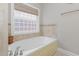 Bathroom featuring a soaking tub with a tiled backsplash and a window at 812 Canyoncreek Ln, Fuquay Varina, NC 27526