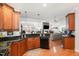 Open concept kitchen with granite countertops, dark wood cabinets, hardwood floors, and seamless connection to living area at 812 Canyoncreek Ln, Fuquay Varina, NC 27526