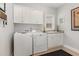 Bright laundry room features a washer, dryer, ample counter space, storage cabinets, and natural light from the window at 812 Canyoncreek Ln, Fuquay Varina, NC 27526