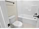 Clean bathroom featuring a toilet, shower-tub combo with tiled walls, and bronze fixtures at 83 Nottoway Lane, Wendell, NC 27591
