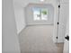 Bright bedroom featuring carpeted floors, scenic views from the window, and an entry door at 83 Nottoway Lane, Wendell, NC 27591