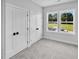Bright bedroom featuring double closets, carpeted floors, and scenic views from the double windows at 83 Nottoway Lane, Wendell, NC 27591