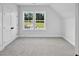 Bright bedroom featuring a double closet, carpeted floors, and scenic views from the double windows at 83 Nottoway Lane, Wendell, NC 27591