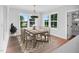 Bright dining room featuring hardwood floors, a modern chandelier, and large windows with views of the yard at 83 Nottoway Lane, Wendell, NC 27591