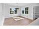 Sun-drenched dining room with wood floors and a modern chandelier at 83 Nottoway Lane, Wendell, NC 27591