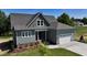 Beautiful two-story home with a gray roof, attached garage, manicured lawn, and lush landscaping at 83 Nottoway Lane, Wendell, NC 27591