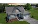 Beautifully landscaped, the charming home features a gray roof, an attached garage, and light green siding at 83 Nottoway Lane, Wendell, NC 27591
