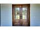 Close-up of wood double doors, providing a glimpse into the home and showcasing quality craftsmanship at 83 Nottoway Lane, Wendell, NC 27591