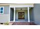 Charming covered front entrance with stately columns, brick steps, and elegant wood double doors at 83 Nottoway Lane, Wendell, NC 27591