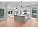 Bright, open kitchen featuring a center island, modern pendant lighting, and stainless steel appliances at 83 Nottoway Lane, Wendell, NC 27591