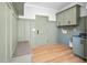 Mudroom featuring green wainscoting, built-in bench, and ample storage with cabinets and hooks at 83 Nottoway Lane, Wendell, NC 27591