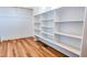 Bright walk-in closet features custom shelves, wood floor, and space for organized storage at 83 Nottoway Lane, Wendell, NC 27591