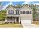 Charming two-story home featuring a cozy front porch and an attached garage at 8708 Poteat Dr, Wake Forest, NC 27587