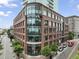 Modern brick commercial building featuring a glass facade with a WeWork sign and street-level retail space at 110 N Corcoran St # 2304, Durham, NC 27701