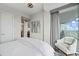 Bedroom with a chair and balcony access, showing an ensuite bathroom through an open door and colorful art at 110 N Corcoran St # 2304, Durham, NC 27701