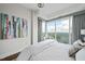 Bedroom featuring city views from floor-to-ceiling windows, with an upholstered bed, side chair, and area rug at 110 N Corcoran St # 2304, Durham, NC 27701