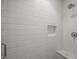 Close up of white tiled shower stall with marble bench and shelf at 110 N Corcoran St # 2304, Durham, NC 27701