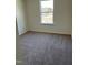 A cozy bedroom featuring neutral carpeting and a bright window overlooking the outdoors at 1117 Mountain Crown St, Durham, NC 27704
