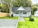 Nice single-story home featuring a cozy front porch with white railings and a walkway leading to the blue front door at 1210 Shaw St, Burlington, NC 27217