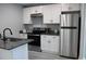 Modern kitchen features stainless steel appliances, white cabinets, and gray countertops at 1210 Shaw St, Burlington, NC 27217