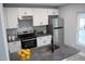 Modern kitchen features stainless steel appliances, white cabinets, and gray countertops at 1210 Shaw St, Burlington, NC 27217