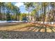 Large grassy backyard featuring tall trees, a white fence, trampoline, and hammock ready for Gathering fun at 125 Pinemere Ct, Cameron, NC 28326