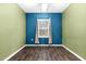Cozy bedroom with blue accent wall, modern chandelier, wood floors, and natural light at 172 Great Gln, Rocky Mount, NC 27804