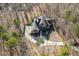 Aerial view of an expansive home nestled in a wooded area, highlighting the property's privacy and size at 209 Democracy Pl, Apex, NC 27523