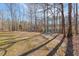 Backyard with a fire pit and Adirondack chairs, creating a cozy gathering spot amidst nature at 209 Democracy Pl, Apex, NC 27523