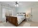 Cozy bedroom with a decorative ceiling fan, wooden bed frame, and patterned wallpaper at 209 Democracy Pl, Apex, NC 27523