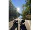 Two chairs on a wooden dock overlooking the calm, sunlit lake surrounded by trees at 209 Democracy Pl, Apex, NC 27523
