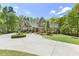 The house features a circular driveway with a landscaped entrance and lush greenery around its manicured lawn at 209 Democracy Pl, Apex, NC 27523