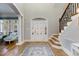 Spacious foyer featuring elegant staircase and intricate glass-paneled front door at 209 Democracy Pl, Apex, NC 27523