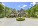 Beautiful brick home featuring manicured landscaping, a circular driveway, and classic architectural details at 209 Democracy Pl, Apex, NC 27523
