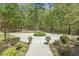 Well-maintained front yard showcasing lush greenery, a circular driveway, and beautiful landscaping details at 209 Democracy Pl, Apex, NC 27523