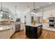 Bright kitchen features a black island, stainless steel appliances, granite countertops, and hardwood floors at 209 Democracy Pl, Apex, NC 27523