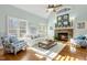 Cozy living room with a stone fireplace, vaulted ceilings, plantation shutters, and ample natural light at 209 Democracy Pl, Apex, NC 27523